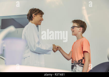 Boy greeting dentist, shaking hands Stock Photo