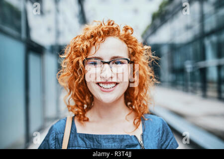 Portrait of a young redheaded woman wearing glasses, smiling