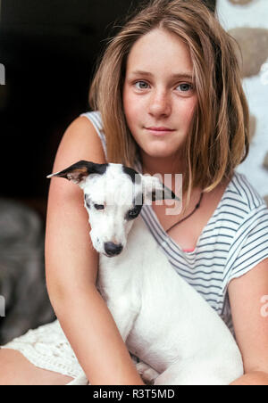 Portrait of freckled girl with puppy on her lap