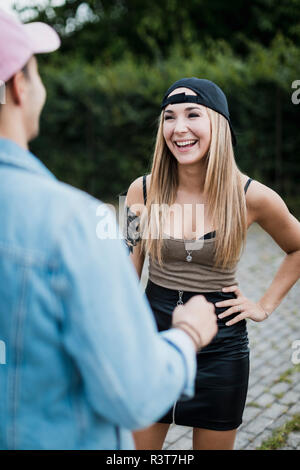 Young woman laughing at man outdoors Stock Photo