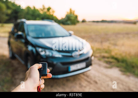 Man opening car with remote control key, close-up Stock Photo