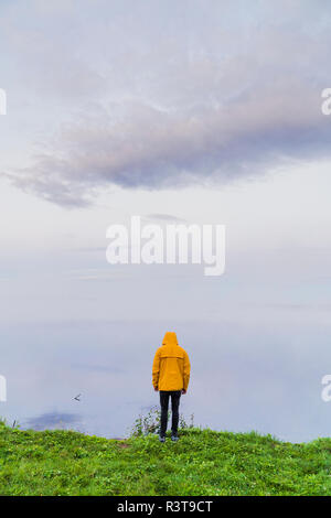 Lonely an standing at lake, looking at the fog
