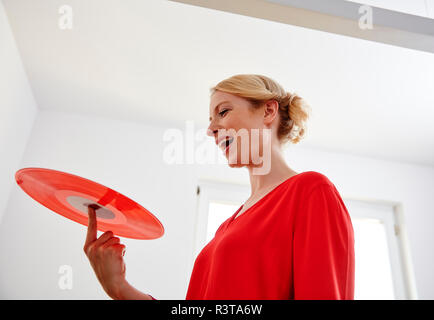 Happy young woman holding red vinyl record Stock Photo
