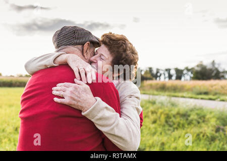 Senior couple hugging in rural landscape Stock Photo