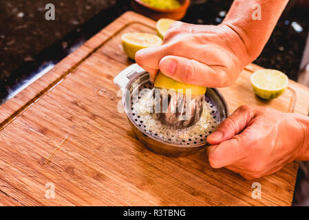 Hands squeezing the juice of a lemon. Stock Photo