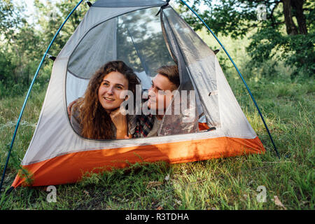 Young couple camping in nature, lying in tent, taking a break Stock Photo