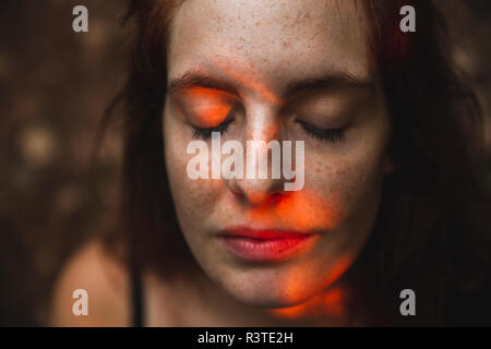Portrait of young woman with freckles closing her eyes Stock Photo