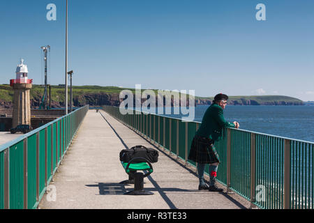 Ireland, County Waterford, Dunmore East, man in kilt, harbor Stock Photo