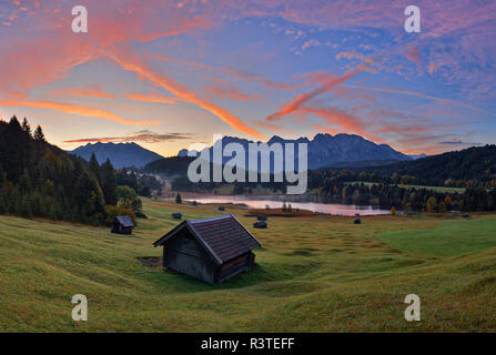 Germany, Bavaria, Werdenfelser Land, lake Geroldsee with hay barn at sunset, in background the Karwendel mountains at sunrise Stock Photo