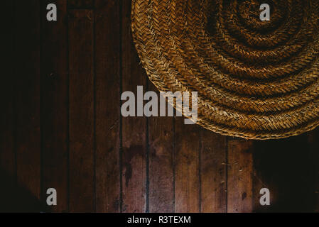 Circular wicker mat on wooden floor background, view from above. Stock Photo