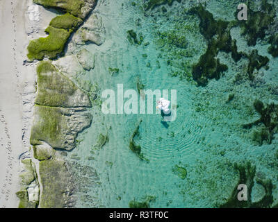 Indonesia, Bali, Aerial view of Karma Kandara beach, one woman, airbed floating on water Stock Photo