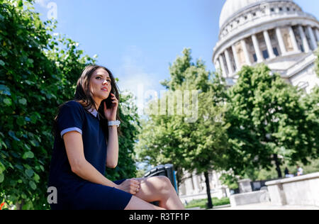 UK, London, young woman talking on the phone near St. Paul's Cathedral