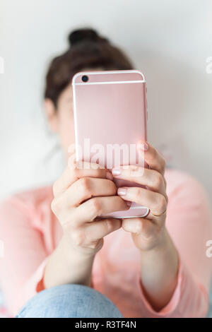 Woman's hands holding pink smartphone, close-up Stock Photo