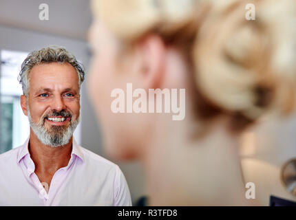 Smiling mature man looking at female colleague in office Stock Photo