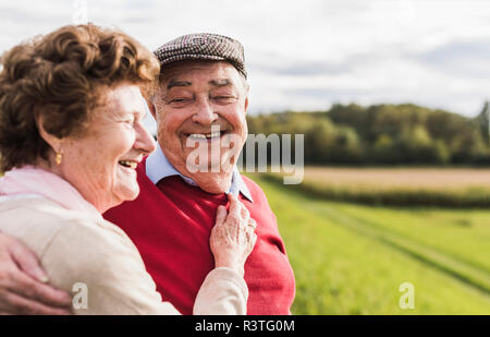 Happy senior couple embracing in rural landscape Stock Photo