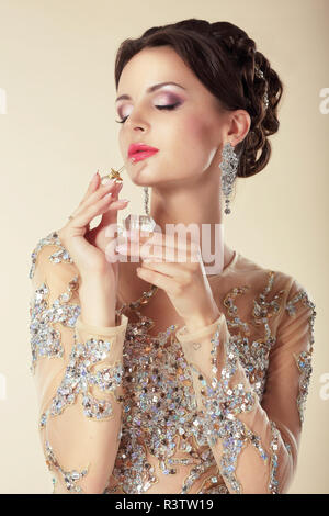 Young Brunette with Perfume Bottle. Fragrance Stock Photo