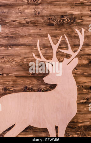 Suluet deer with plywood on the background texture of wood.Christmas photo with place for text. Stock Photo