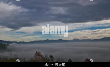 Above the clouds in the Swiss alps during autumn Stock Photo