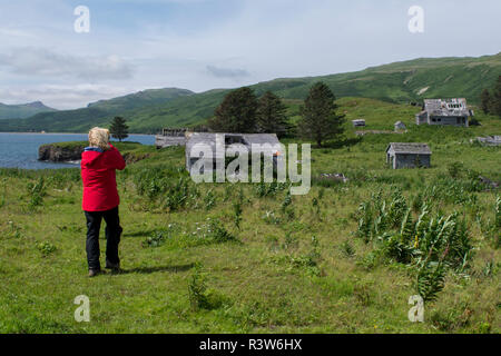 Alaska, Aleutian Islands, Unga Island. Unga Village, expedition tourist exploring abandoned gold mining village. Stock Photo