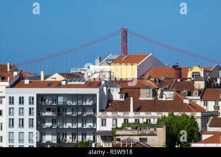 The 25 de Abril bridge towers above the city buildings in Lisbon, Portugal. Until 1974, this bridge was name Salazar bridge. Stock Photo