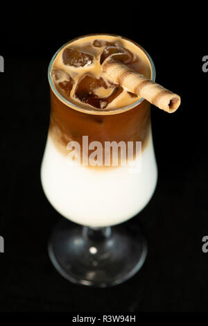 Alcoholic coffee cocktail with coffee liqueur and milk with isolated black background