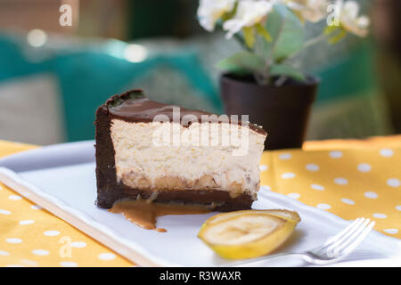 Banana split cake with caramel sauce and banana pieces on yellow ground Stock Photo