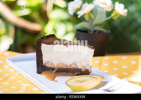 Banana split cake with caramel sauce and banana pieces on yellow ground Stock Photo