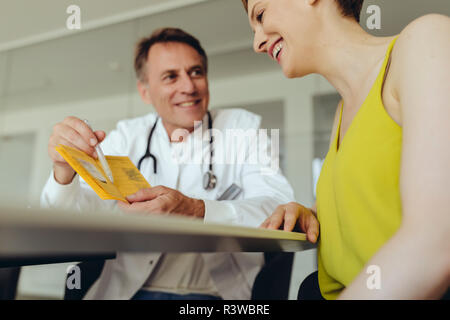 Woman discussing teatment with her doctor Stock Photo