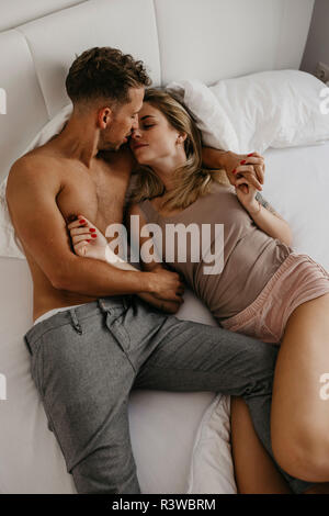 Romantic young couple kissing in bed Stock Photo