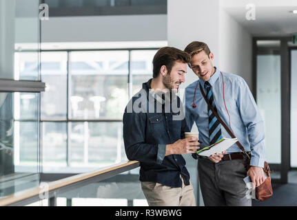 Two colleagues talking on office floor Stock Photo