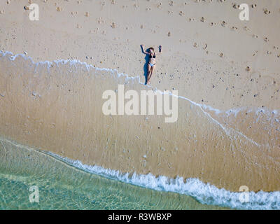 Indonesia, Bali, Melasti, Aerial view of Karma Kandara beach, woman lying on beach Stock Photo