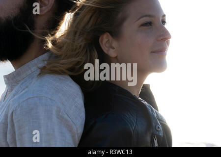 Young couple standing back to back Stock Photo