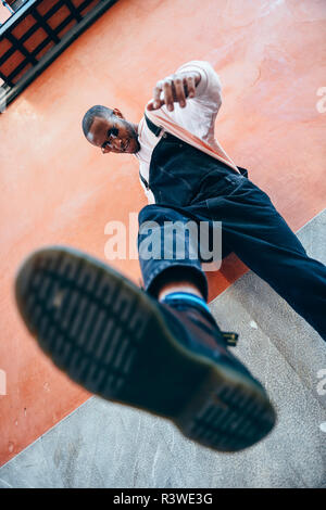 Young black man man kicking towards the ground. Lifestyle concept. Stock Photo