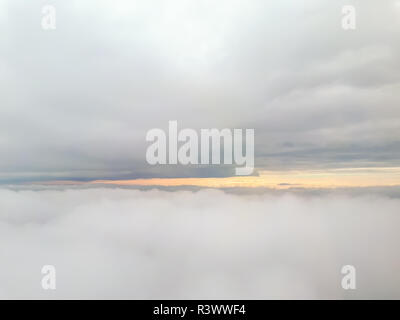 A front view of many clouds from an airplane with a wide cumulus clouds in the base and the top of the picture Stock Photo