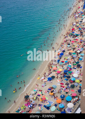 Tropea, Italy - August 21, 2018: Beach with crystalline sea crowded with swimmers. Top view. Stock Photo