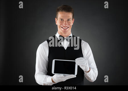 Waiter Holding Cellphone Stock Photo