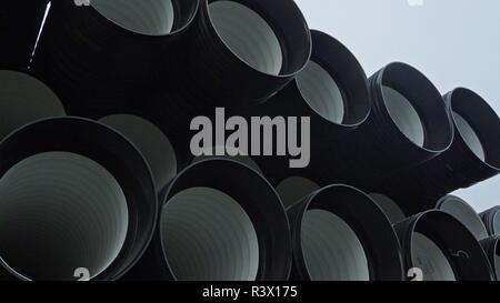 Warehouse of finished plastic pipes industrial outdoors storage site. Manufacture of plastic water pipes factory. Process of making plastic tubes on t Stock Photo