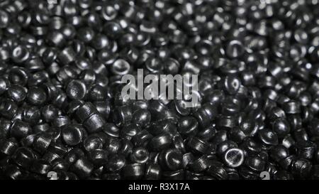 Plastic black gray granulated crumb. Manufacture of plastic water pipes of the factory. Process of making plastic tubes on the machine tool with the u Stock Photo