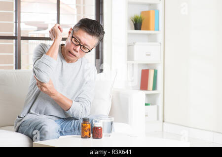 Mature Asian man elbow pain Stock Photo