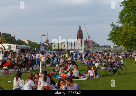 People enjoying a sunny day next to Main river in the city of Frankfurt, Germany Stock Photo