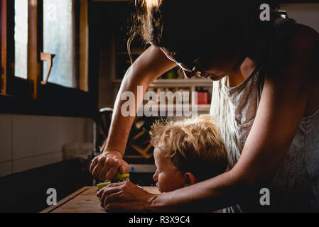 Mother helped her son to squeeze fruit. Stock Photo