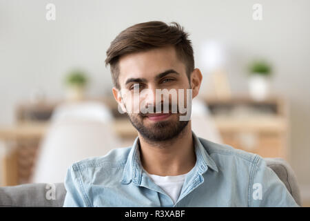 Portrait of smiling male looking at camera sitting at home Stock Photo