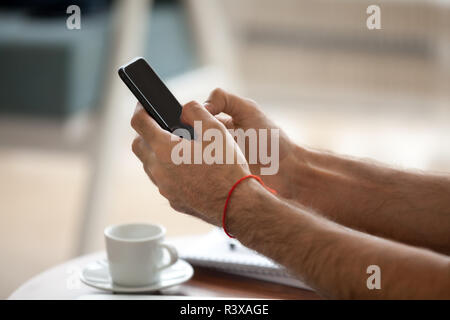 Close up of man using smartphone writing message Stock Photo