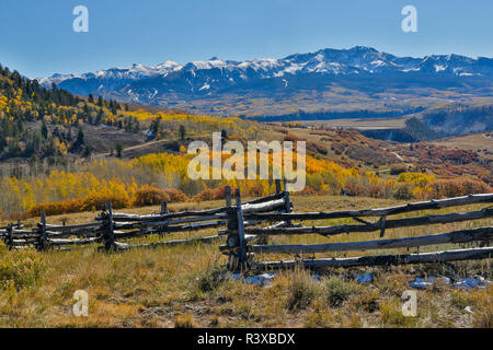 Dallas Mountain and San Juan Mountain Range, Colorado, Autumn colors and aspens glowing gold with wooden fence line Stock Photo