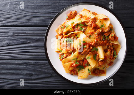 Italian Taccozzette con Stracotto pasta with slow cooked pork in a spicy sauce close-up on a plate on the table. Horizontal top view from above Stock Photo