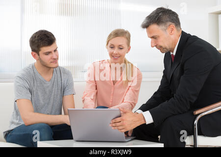 Consultant Explaining Investment Plan To Couple Stock Photo