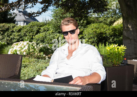 student is reading a book in the garden Stock Photo