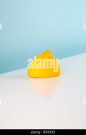 Wedges of tangerine on white table. Minimalistic image of piece of orange fruit on bright studio background Stock Photo