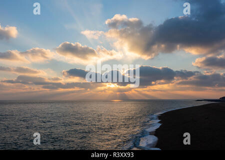 Crepuscular rays over the English Channel with the Folkestone coastline, Kent, England, UK. Taken in November. Stock Photo