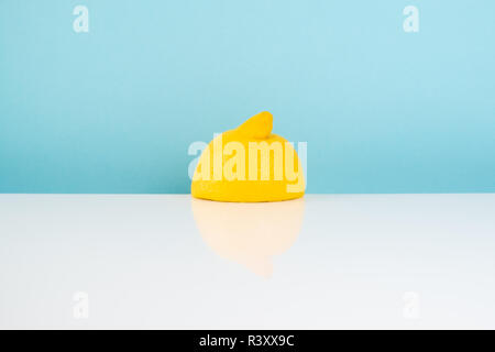 Half of lemon on white table. Minimalistic image of yellow citrus on bright  studio background Stock Photo